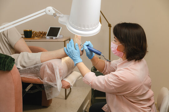 Beautician doing procedure on clients feet