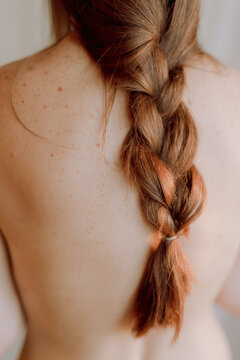 braid of a woman on a naked back