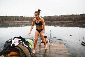 Energetic woman taking a towel after a cold swim in a lake