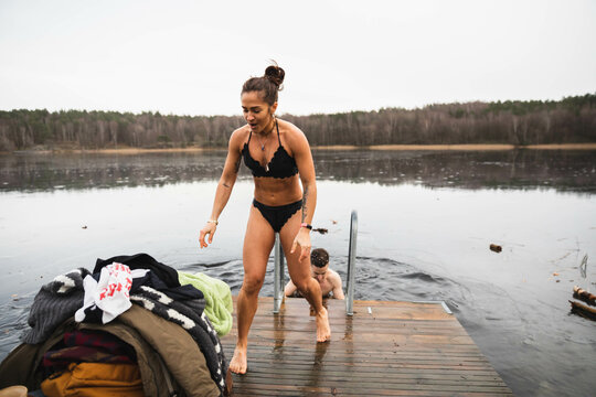 Energetic woman taking a towel after a cold swim in a lake