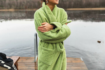 Unrecognizable woman wearing a bathrope next to a lake