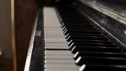 Rack focus old dusty piano close up view of yellow keys from time. Old broken keyboard musical...