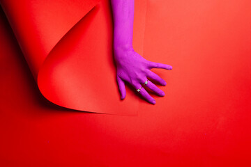 Purple painted hand on a red background