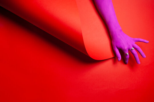 Purple painted hand on a red background