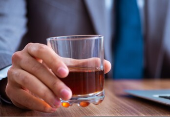 Male employee drinking alcohol and smoking cigarettes at workpla