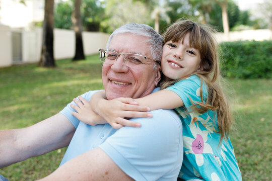 A girl hugging grandfather in the park