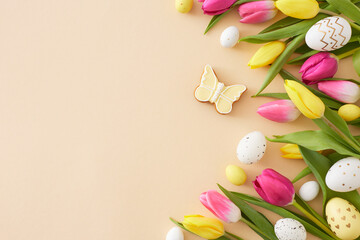 Fototapeta na wymiar Easter decor concept. Top view composition of colorful easter eggs yellow pink tulips flowers and butterfly cookie on isolated beige background with copyspace