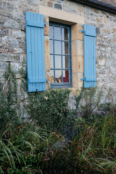 blue window on stone house with shutters in France