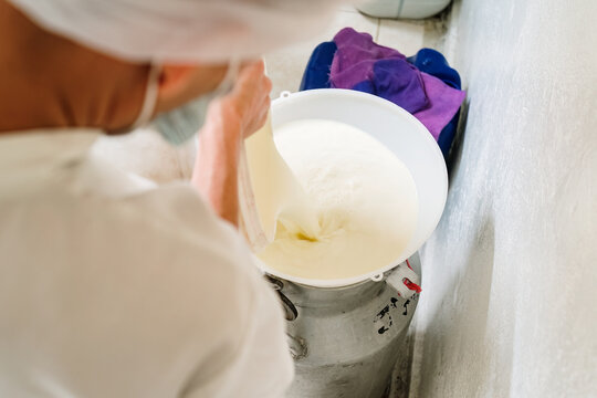 Employee pouring milk into an aluminum canteen