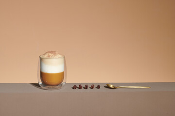 cappuccino with cinnamon on a foam in a transparent cup