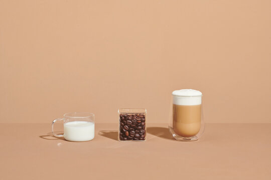 Ice coffee in a tall glass with cream poured with ingredient raw