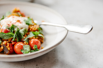 A dish of pearl couscous with tomatoes and aubergine.