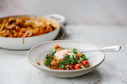 A dish of pearl couscous with tomatoes and aubergine.