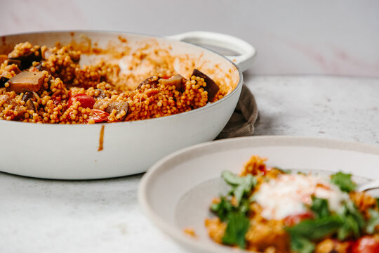A dish of pearl couscous with tomatoes and aubergine.