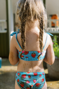 backside of toddler girl in swimsuit with fishtail braids