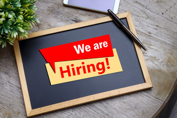 WE ARE HIRING message on the black chalkboard. Human resource management concept