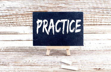 PRACTICE text on the Miniature chalkboard on wooden background