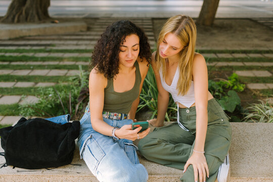 Two young women are looking at a smartphone