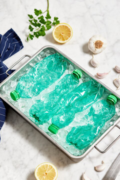 Container of plastic bottles near lemon and garlic
