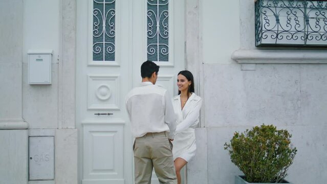 Coquettish lady dating man at urban place. Romantic lovely pair holding hands