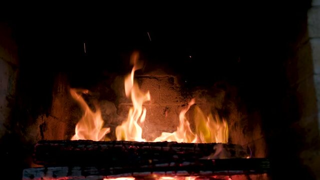 Close up of logs burning in a fireplace in the sitting room of a homeClose up of logs burning in fireplace in the sitting room of a home. Cozy Christmas Atmosphere with warm light