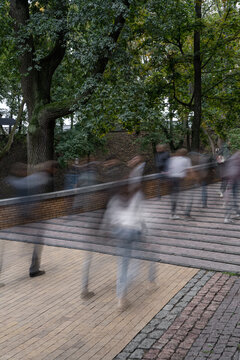 Walking people blurred in motion in city park
