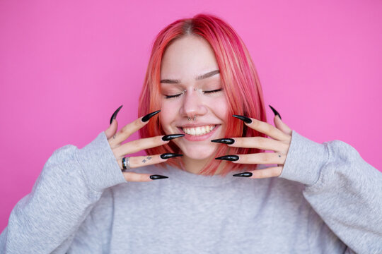 Smiling young woman showing long black nails