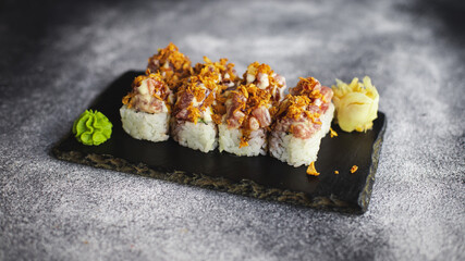 Sushi with wasabi and ginger on a black stone tray on a dark background. Mockup