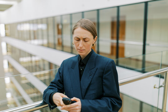  Woman wearing man classic suite with  retro cellphone 