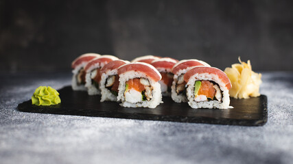 Sushi with wasabi and ginger on a black stone tray on a dark background. Mockup