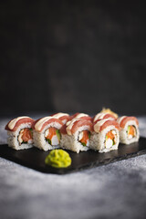 Sushi with wasabi and ginger on a black stone tray on a dark background. Mockup