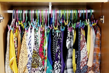 Colorful clothes on hangers in the wardrobe. Women's clothing