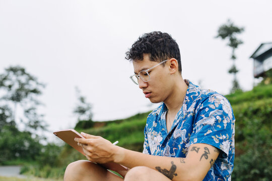 A Young South Asian Man Using A Tablet