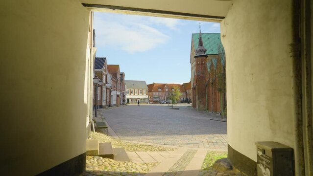 2022 - People walk their dogs and ride bicycles past the Ribe Cathedral in Denmark.