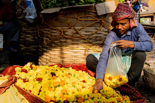 A seller sifts through flowers on the street in India