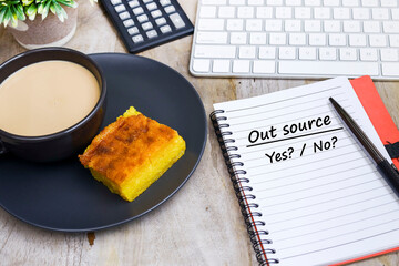 A notebook with a message on Out Source, Yes or No. Human resources concept 