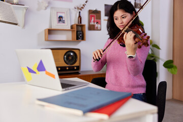 Female violinist during online lesson at home