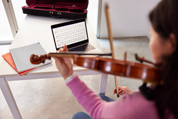 Female violinist during online lesson at home
