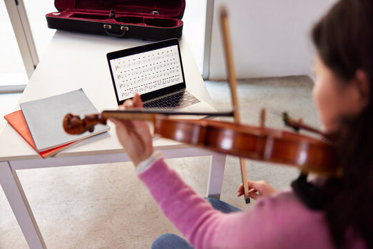 Female violinist during online lesson at home