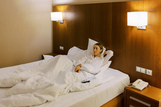 Alone tired woman wearing white shirt on the bed .
