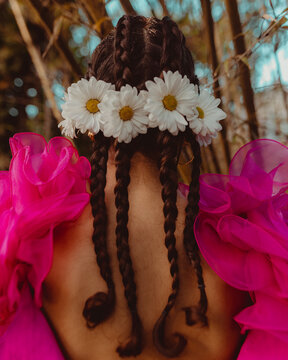 Young afro latinx woman's back wearing braids