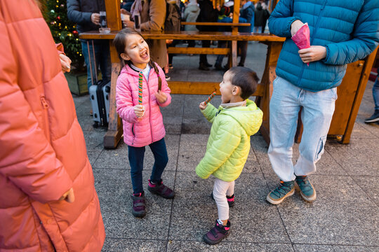 Kids on Christmas market enjoy lollipops