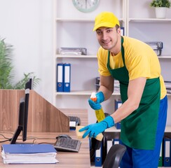 Young male contractor cleaning the office