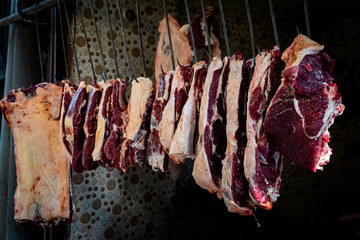 Freshly butchered meat hanging on hooks at a street stall in India