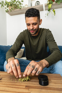 man preparing a marijuana cigarette