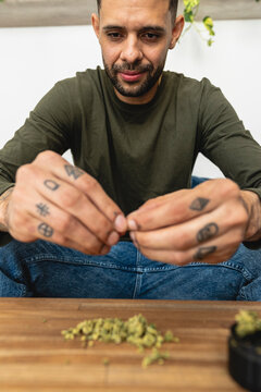 man preparing a marijuana cigarette