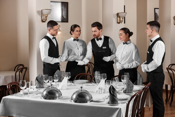People setting table during professional butler courses in restaurant