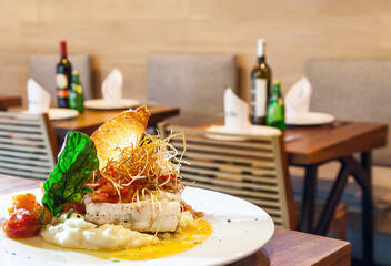 White Fish and Mashed Potatoes with Restaurant Background
