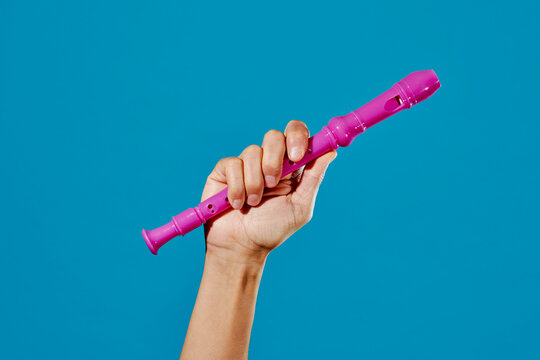 man has a pink recorder flute in his hand