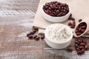 Kidney bean flour and seeds on wooden table. Space for text